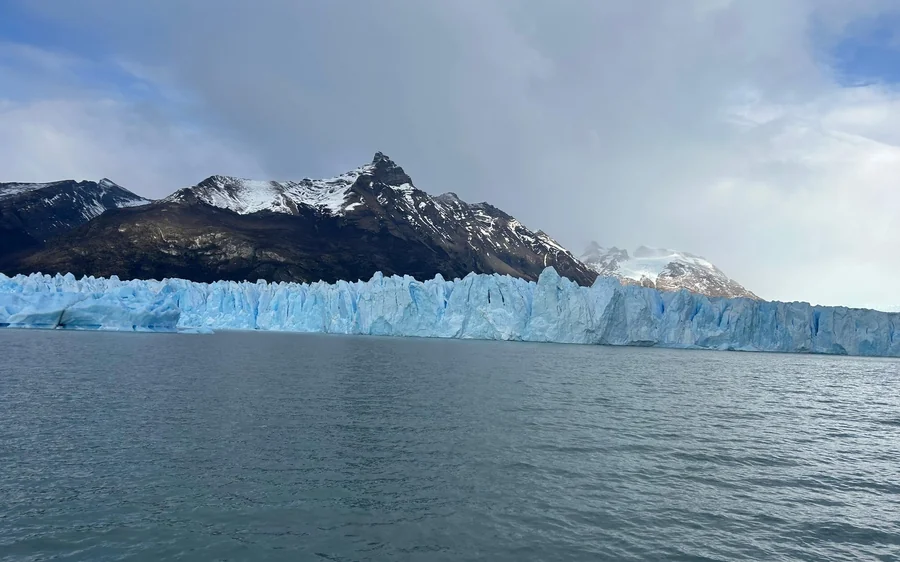 A boat on Lago Argentino below the ice wall of the Perito Moreno Glacier